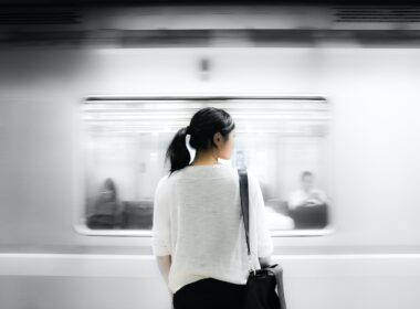 woman in white elbow-sleeved shirt standing near white train in subway