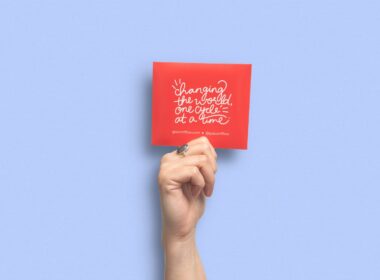 person holding red and white card