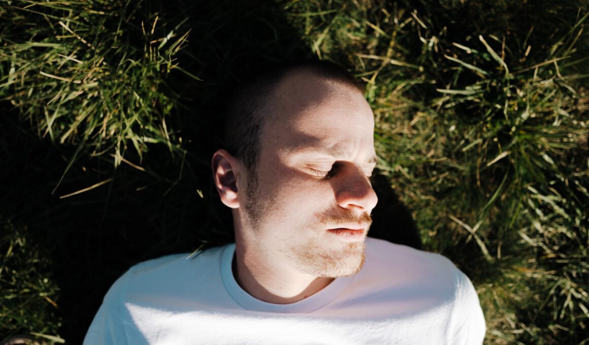 a man laying in the grass with his eyes closed